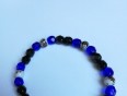 Zapestnica z pretežno modrimi perlami, vmes črne in bele perle
