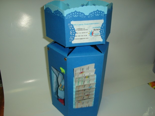 Škatlica - Škatlica iz papirja za vizitke. Na vrhu ima prostor za bombone ali pisarniške drobnarije. V notranjosti pa dodatna presenečenja, ki se odkrijejo ob stranskem oknu.